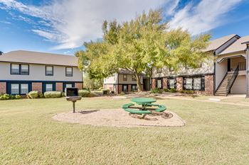 Courtyard with mature trees and green picnic tables
